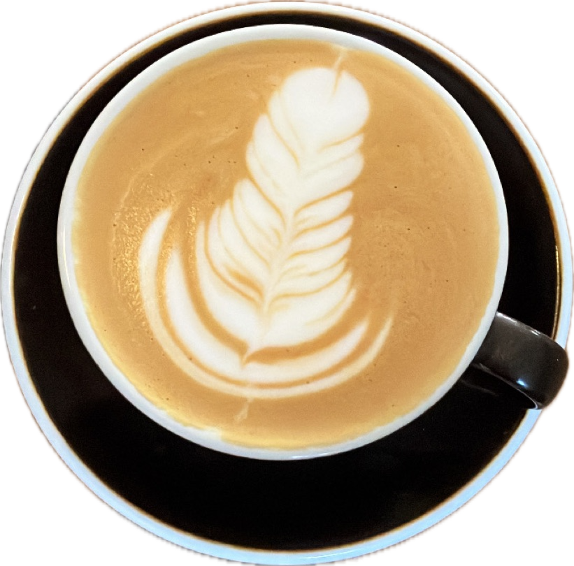 A single latte with rosetta art in a black cup and saucer, shot from above
