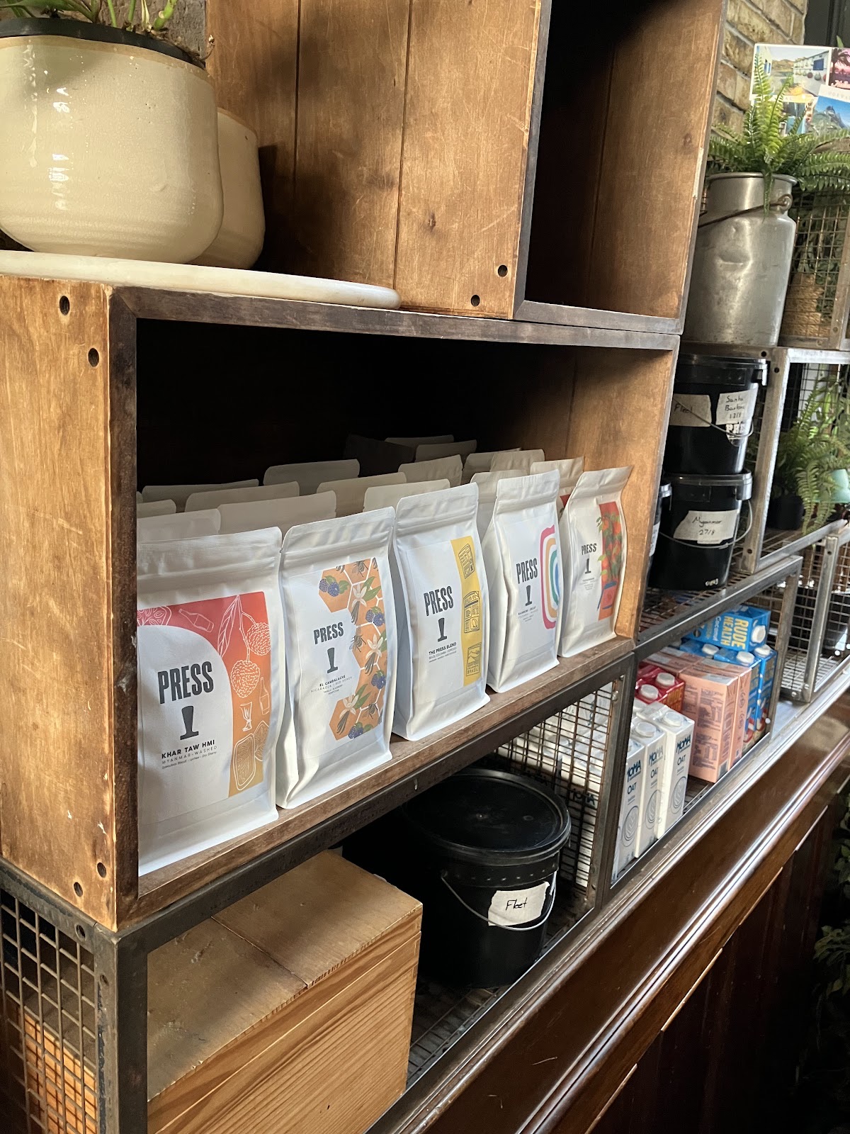 Wooden shelving stacked with retail bags of coffee beans