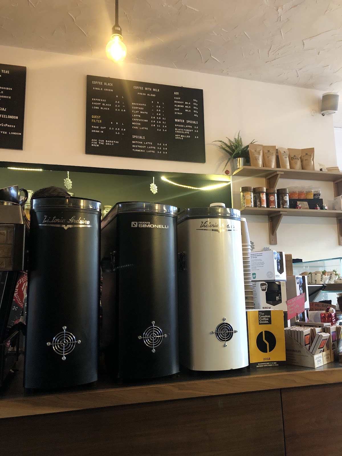 Coffee grinders and retail bags of beans on the back bar