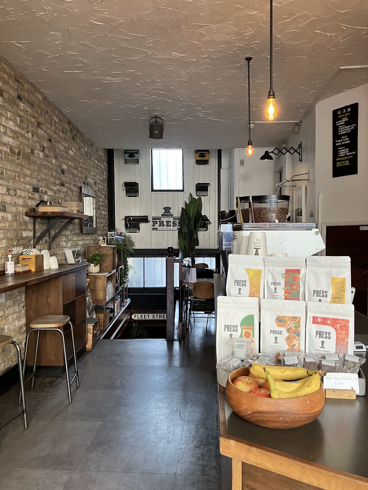 Wide interior along the exposed-brick wall with a high bar bench and stool